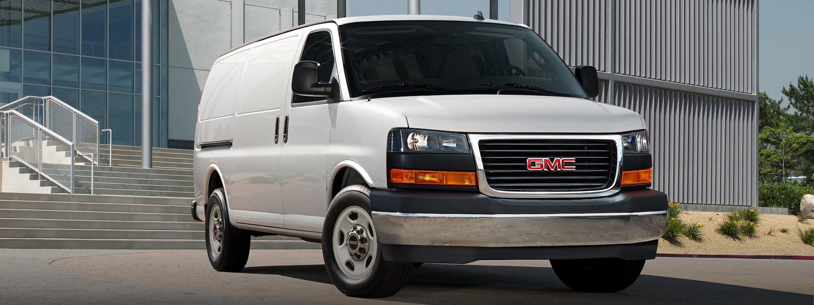 GMC Savana Cargo Van parked outside a commercial building